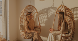 Duas mulheres conversando em cadeiras suspensas em sala de espera da Sea Yourself